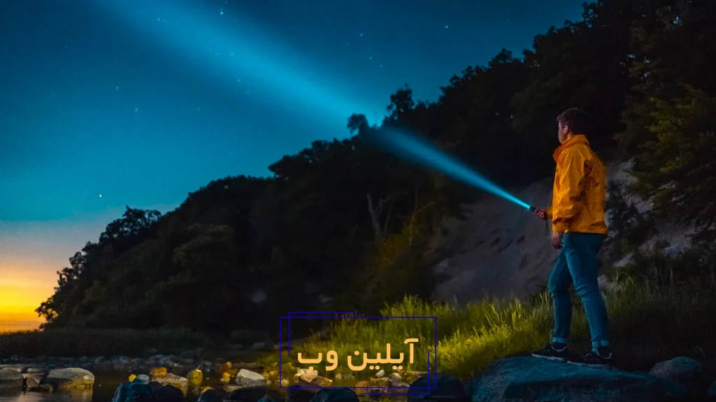 فردی با چراغ قوه در شب